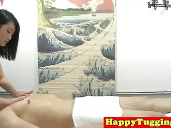 Asian masseuse tugging on client cock